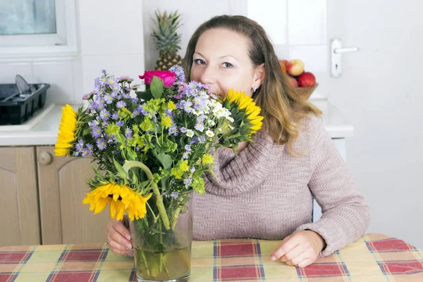 花を持つ肯定的な主婦の肖像画 — ストック写真
