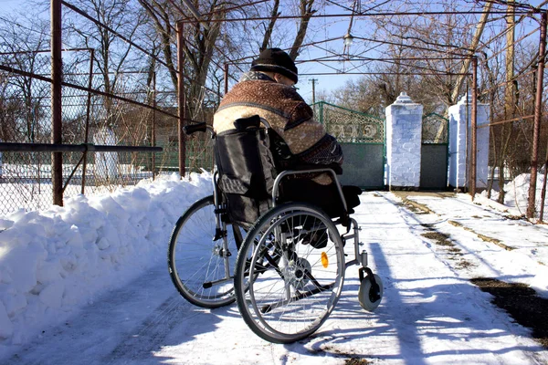 Adult man in wheelchair. Close up photo of male hand on wheel