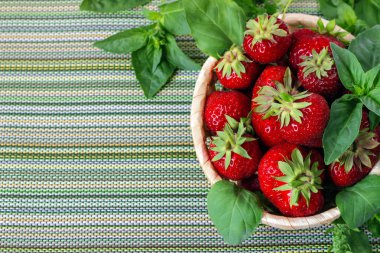 Hasır sepet ve nane yaprakları olgun tatlı çilek.
