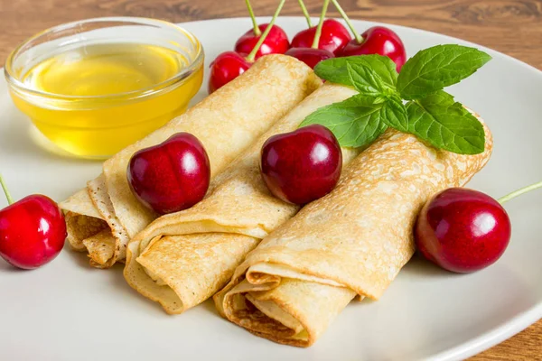Whole gran pancakes with honey, mint and cherries. Useful breakfast. — Stock Photo, Image