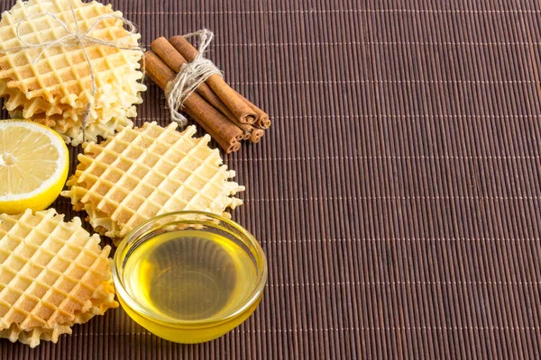 Waffle com canela, mel, limão em um fundo de madeira escura — Fotografia de Stock