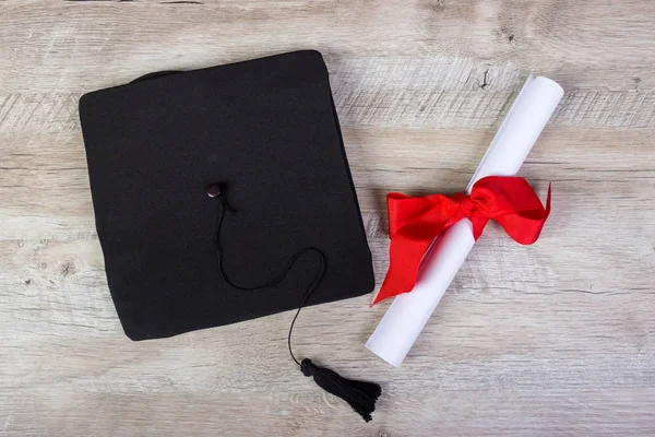 Graduiertenmütze, Hut mit Diplomarbeit auf Holztisch Graduierungskonzept — Stockfoto