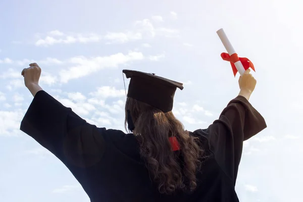 Graduada colocar as mãos para cima e celebrar com certificado em sua mão e sentir tanta felicidade no dia do início. Tonificado — Fotografia de Stock