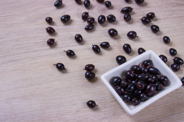 cam üstünde beyaz ahşap masa üstü görüş içinde Siyah frenk üzümü