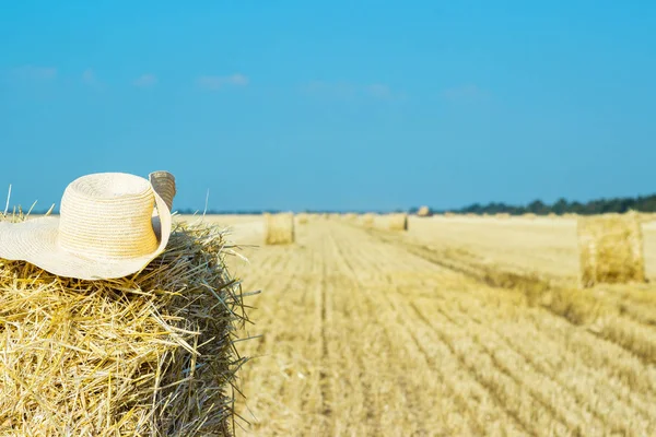 Un cappello da contadino solitario su un pagliaio nel campo dopo un duro lavoro — Foto Stock
