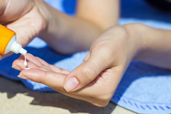 Primer plano de las manos de las mujeres que reciben crema protector solar — Foto de Stock