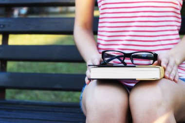 Tezgah ve okuma kitabı parkta oturan genç güzel bir kadın. Güzel kız açık havada yaz günü olduğunu.