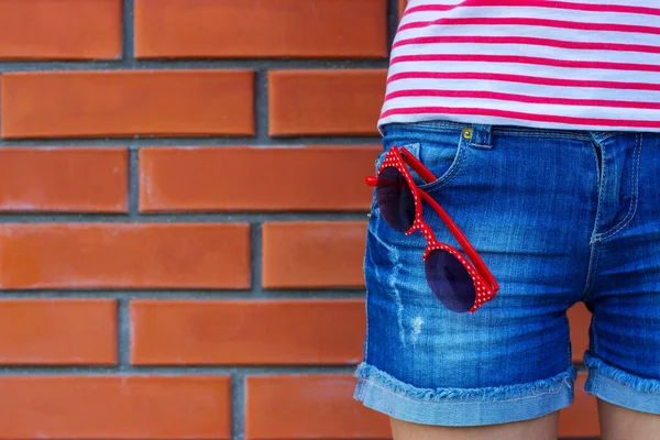 Erkek güneş gözlüğü ile kot pantolon cebinde giyiyor. Moda kavramı