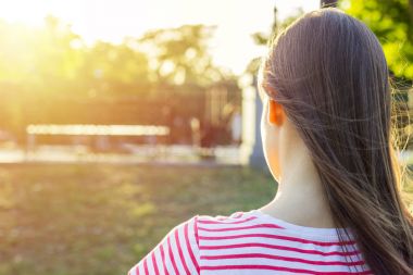 Yaz güneşli gün. Arkadan Görünüm. Genç kız bir parkta bir bankta oturur ve bir kitap okur. Kız işleri, çalışmalar, öğrenme, bir günlük tutar. Yaşam tarzı.