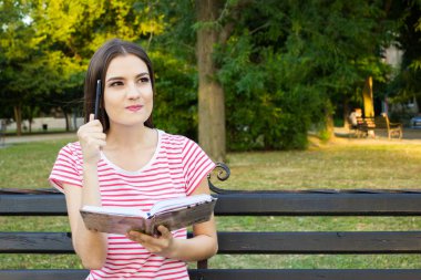 Çekici kız bir şey yeşil park kitap okurken düşünüyorum.