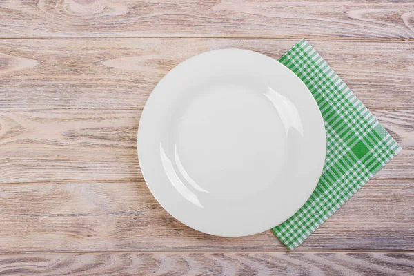Prázdný talíř s ubrouskem na šedý dřevěný stůl — Stock fotografie