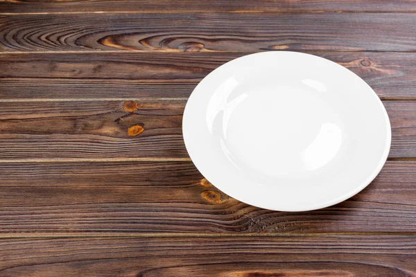 Assiette blanche vide sur table en bois vue du dessus . — Photo