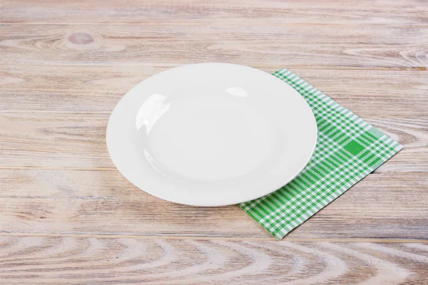Assiette blanche vide sur table en bois, serviette verte — Photo