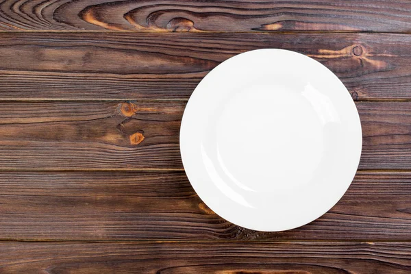 Top view of empty white food plate on a wood background. — Stock Photo, Image