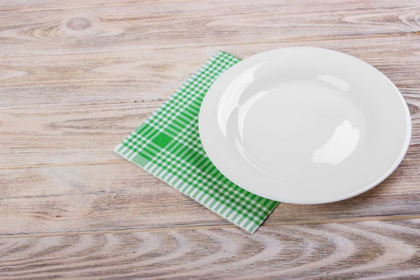 Lege plaat en handdoek over houten tafel achtergrond. Bekijken van boven met kopie ruimte — Stockfoto