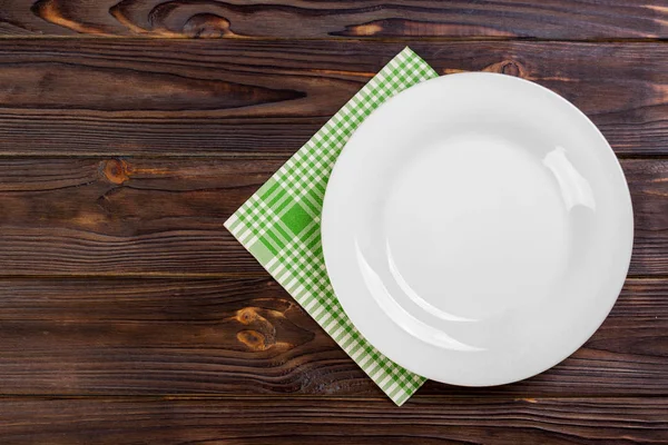 Assiette vide et serviette sur fond de table en bois. Vue d'en haut avec espace de copie — Photo