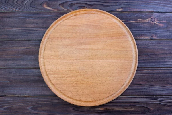 Tabla de cortar pizza en el fondo de la mesa, mesa redonda — Foto de Stock