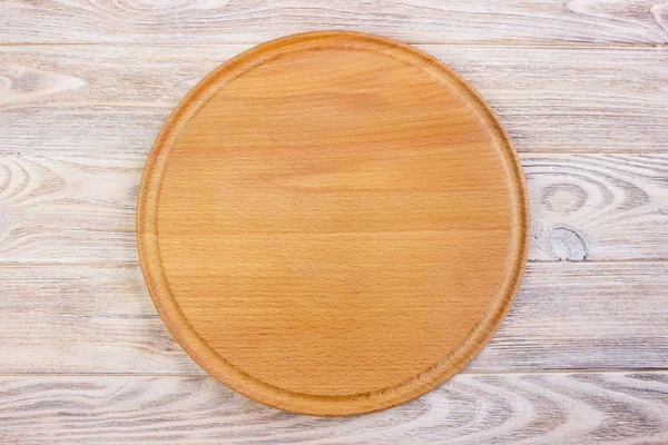 Tabla de cortar redonda vacía en una mesa de madera.Vista superior — Foto de Stock