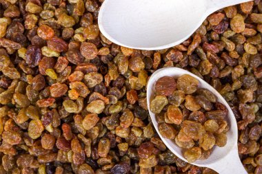 Arka planda bir tahta kaşık, yakın çekim, gıda kuru üzüm