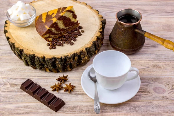 杯白咖啡与巧克力蛋糕上木树桩、 茶勺、 咖啡豆、 茴香、 巧克力和碗与明亮的木桌上的糖多维数据集 — 图库照片