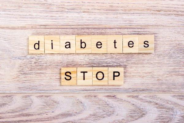 Palabra diabetes en cubos de madera. Detener la diabetes. Sobre una mesa de madera — Foto de Stock