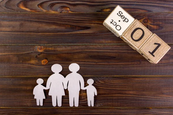 Бумажный силуэт семьи с 1 сентября по декоративному календарю на деревянном фоне. Концепция страхования жизни — стоковое фото