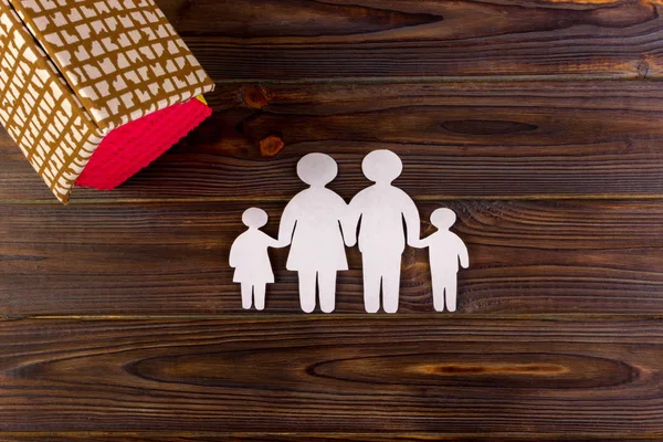 Familia de papel feliz con casa sobre fondo oscuro de madera vintage — Foto de Stock