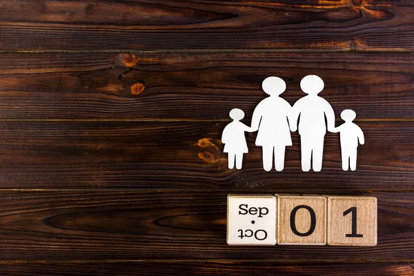 Papier silhouet van familie met 1 September op een decoratieve kalender op houten achtergrond. Levensverzekeringen concept — Stockfoto