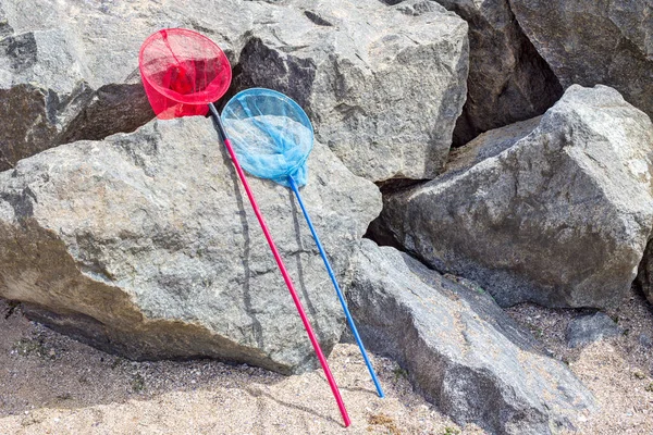 fishing net or butterfly net on a stone near the beach