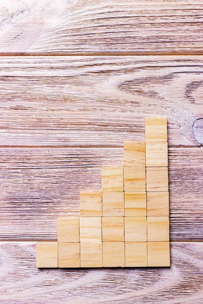 A wooden blocks cube over black wooden textured background with copy space for add word text title. Concept or conceptual Wood block stair or six steps. Cubic.