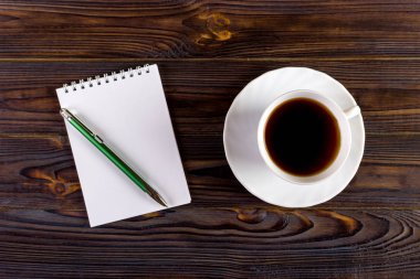 defter kalem ve kahve Kupası ahşap arka plan, iş kavramı ile