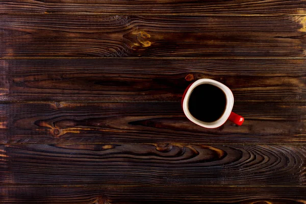 Cup of coffee on wooden table, top view — Stock Photo, Image