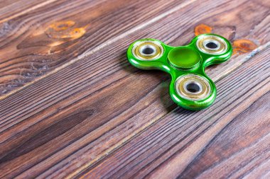 Yeşil topluca spinner stres giderici oyuncak ahşap arka plan üzerinde