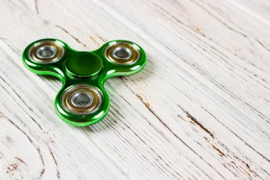 Yeşil topluca spinner stres giderici oyuncak ahşap arka plan üzerinde