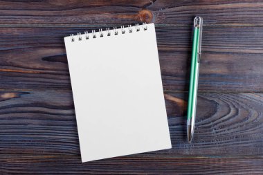 Bir defter ve kalem ahşap arka plan üzerinde