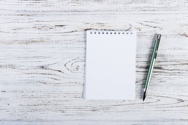 Düşük anahtar sahne rustik ahşap zemin üzerine kalem ile küçük not defteri.