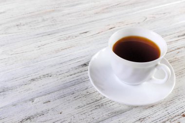 Eski ahşap arka plan üzerinde beyaz kahve fincanı