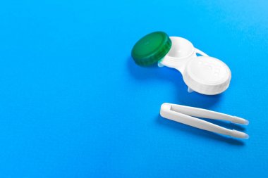 Kontakt lensler ve cımbız mavi zemin üzerine için kapsayıcı