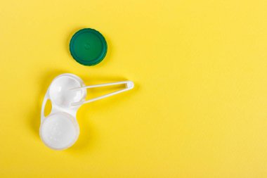 Kontakt lensler için aksesuarlar: Konteyner cımbız sarı arka plan