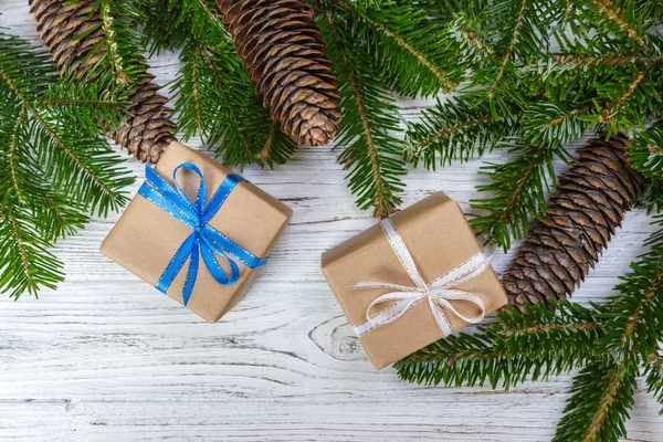 Caja de regalo de Navidad en el fondo de mesa de madera blanca, rama de abeto, conos de pino, marco, vista superior, espacio para el texto —  Fotos de Stock