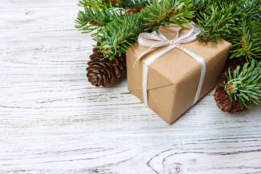 Noel hediye kutusu beyaz ahşap masa arka plan, Ladin şube, çam kozalakları, çerçeve, üstten görünüm, metin için yer