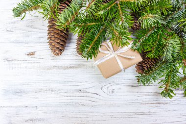 Noel hediye kutusu beyaz ahşap masa arka plan, Ladin şube, çam kozalakları, çerçeve, üstten görünüm, metin için yer
