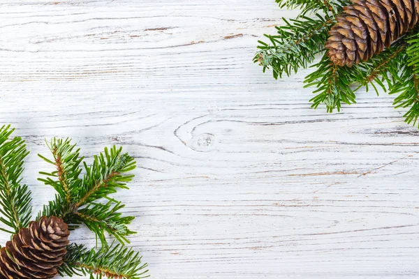 Ahşap arka plan üzerinde koniler ile Noel ağacı dalları