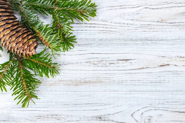 Ahşap arka plan üzerinde koniler ile Noel ağacı dalları