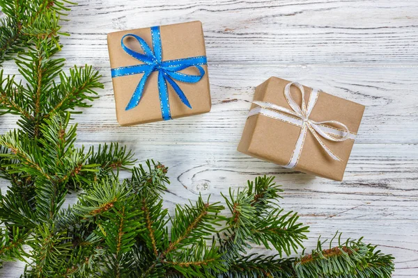 Çam kozalakları ve çam dalları ile karanlık rustik ahşap masa üzerinde Noel hediyeleri sarılmış. Metniniz için kopya alanı ile