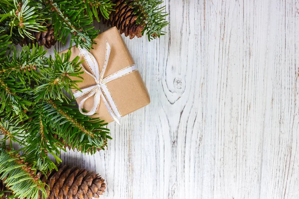 Regalos de Navidad envueltos en mesa de madera rústica oscura con conos de pino y ramas de abeto. Con espacio de copia para su texto —  Fotos de Stock