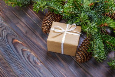 Ahşap arkaplan görünümünde köknar dalları olan hediye kutuları