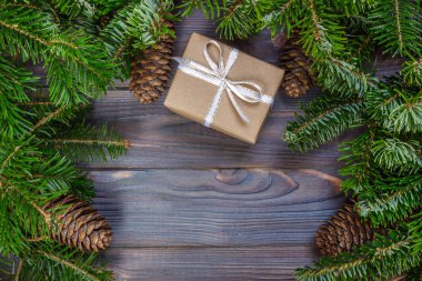 Ahşap arkaplan görünümünde köknar dalları olan hediye kutuları