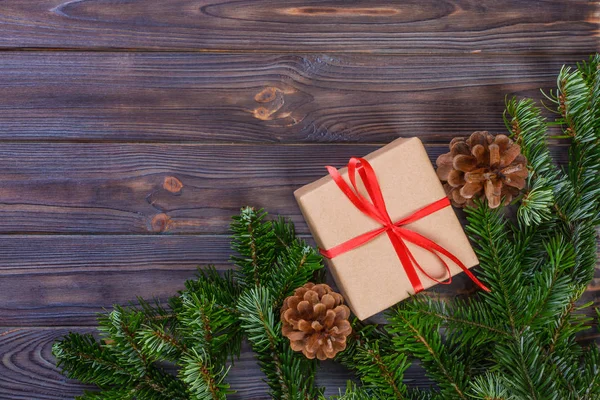 Χριστουγεννιάτικη σύνθεση. Χριστουγεννιάτικο δώρο, πλεκτό κουβέρτα, κουκουνάρια, κλαδιά έλατου σε ξύλινο άσπρο φόντο. Επίπεδη lay, κορυφαία προβολή — Φωτογραφία Αρχείου