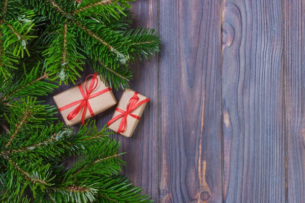 圣诞节背景与木制背景与冷杉的枝条上的圣诞礼物。圣诞节和新年快乐组成。平躺，顶视图 — 图库照片